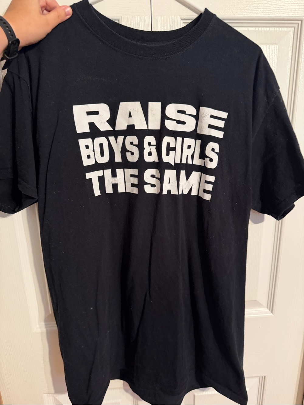 “Raise boys and girls the same” shirt. Large. Creasing in letters
